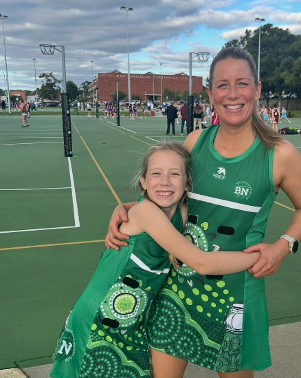 Beaconsfield club members wearing their green artwork netball dresses on court