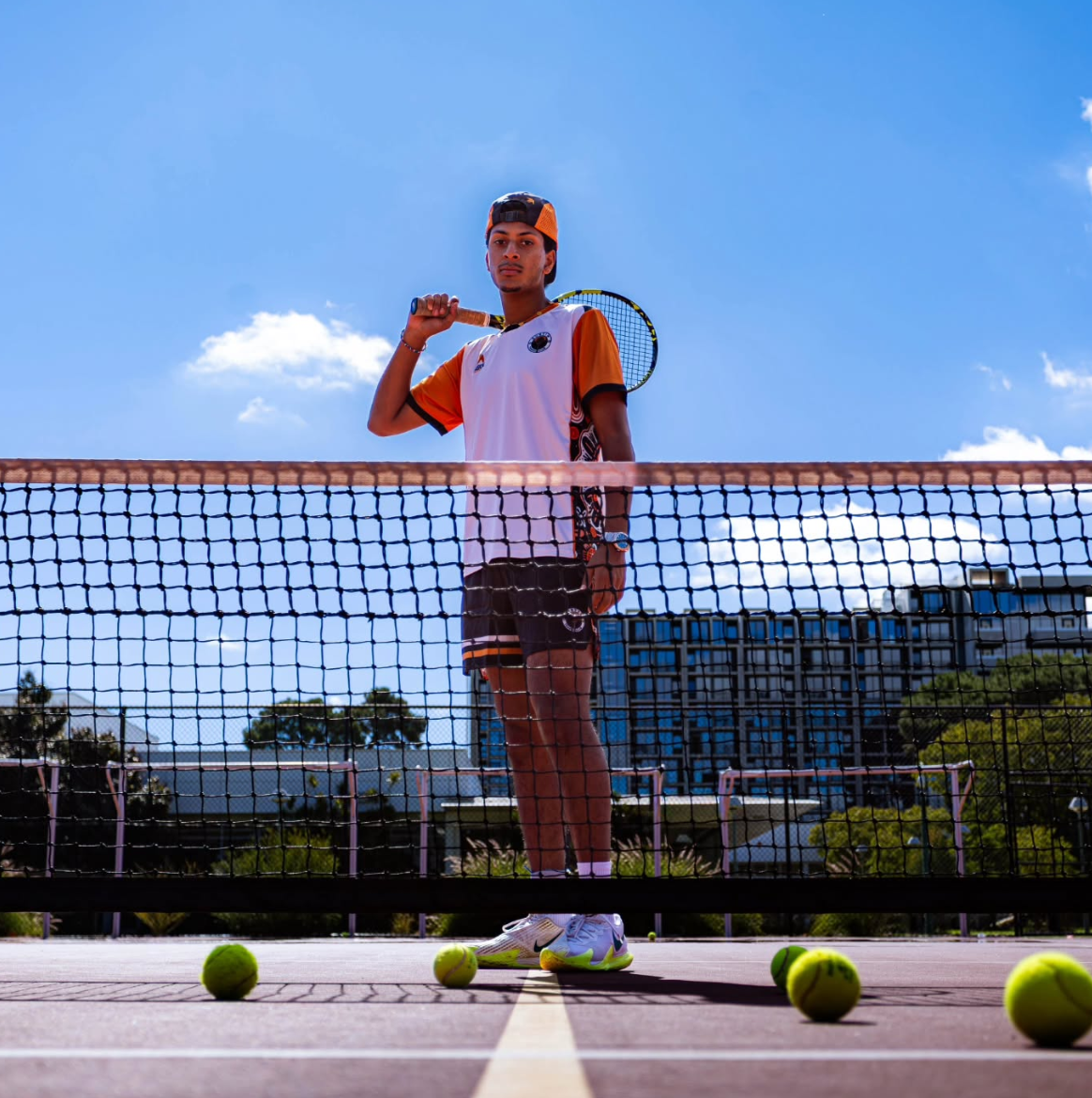 Curtin tennis player standing behind the net in the club pennants kit