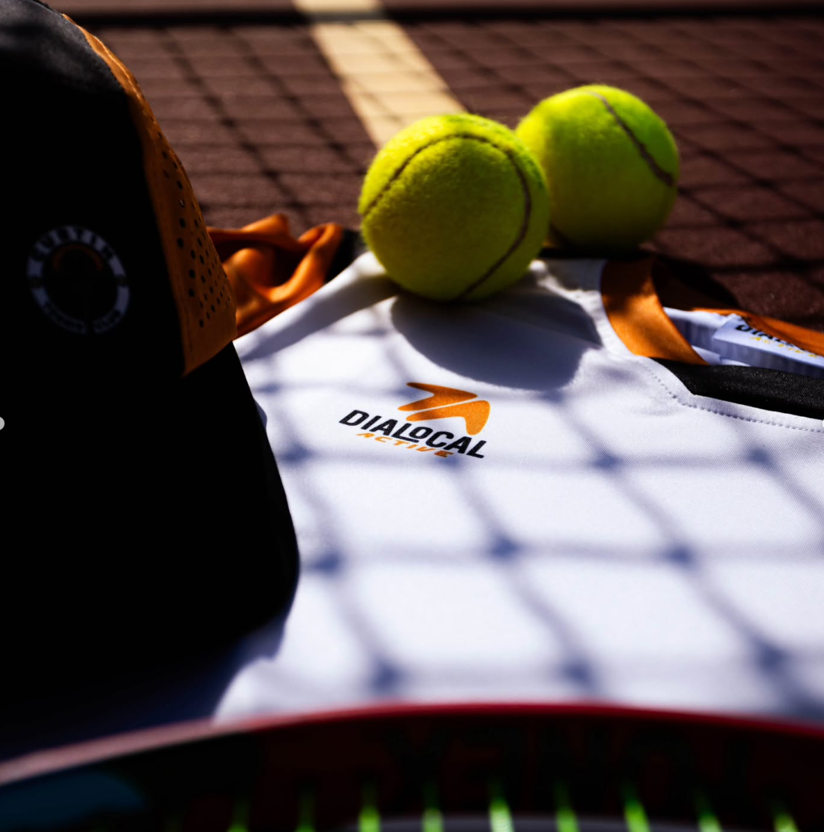 Detail of the Curtin shirt and cap beside tennis balls